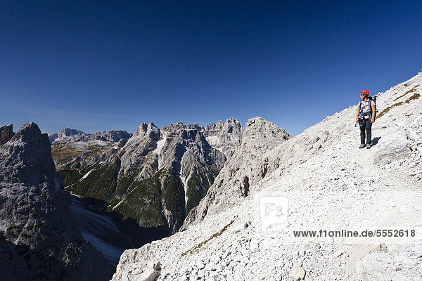 Hikers on the Alpinisteig climbing trail  Dreischusterspitze peak in the back  below the Fischleintal valley  Sexten  South Tyrol  Dolomites  South Tyrol  Italy  Europe