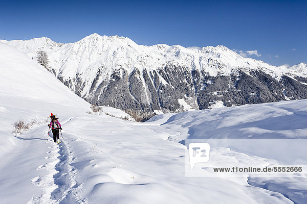 Snowshoer ascending to Jagelealm alpine pasture in Ridnaun Valley above Entholz  looking towards Ridnauntalm alpine pasture  Rosskopf and Telfer Weissen Mountains  Alto Adige  Italy  Europe