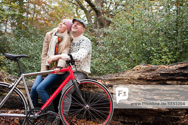 Couple sitting on log with bike