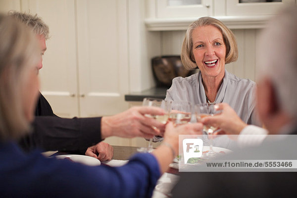 Senior adults toasting wine glasses
