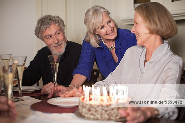 Senior Woman und Freunde mit Geburtstagstorte
