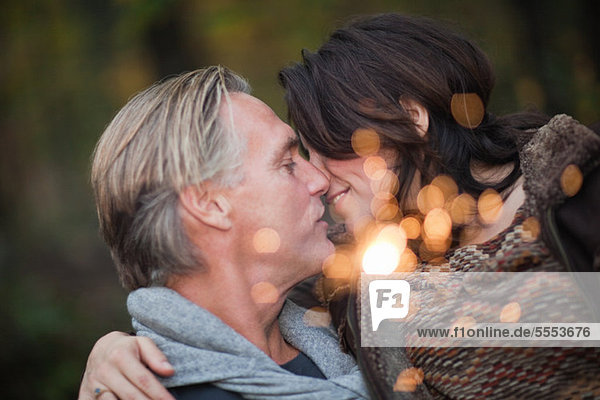 Affectionate mature couple with light from sparkler