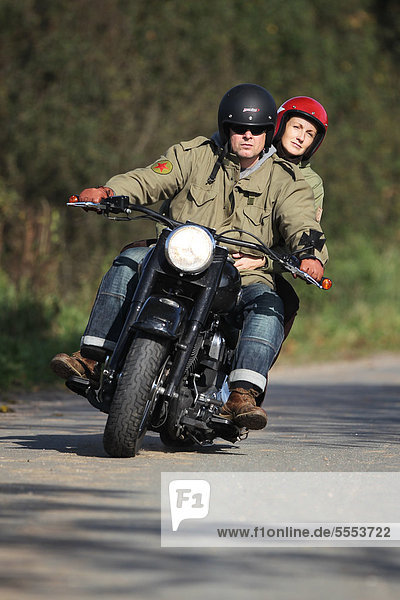 Paar fährt Motorrad auf einer Landstraße