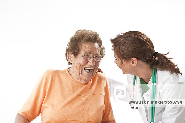 Alte Frau und Ärztin lache zusammen