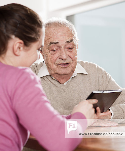 Young woman and senior man with tablet pc