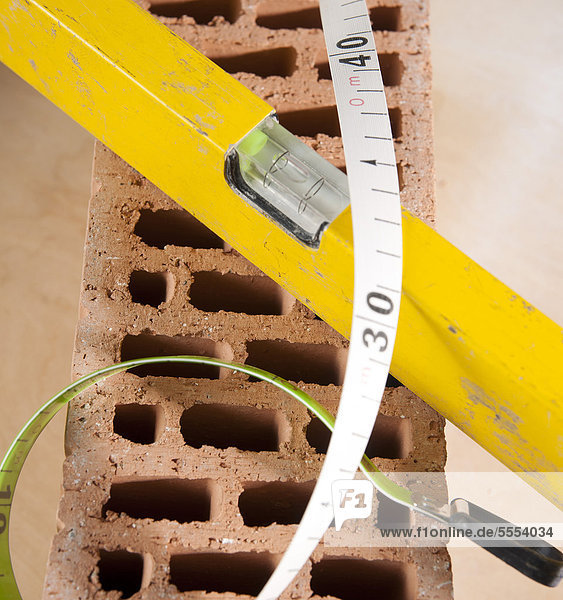 Measuring tape  mechanic's level and claybrick
