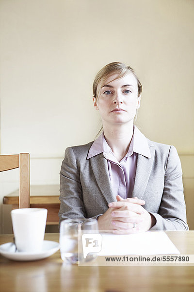 Seriöse Geschäftsfrau sitzt im Cafe