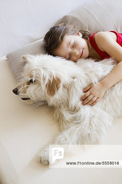 Girl relaxing with dog in bed