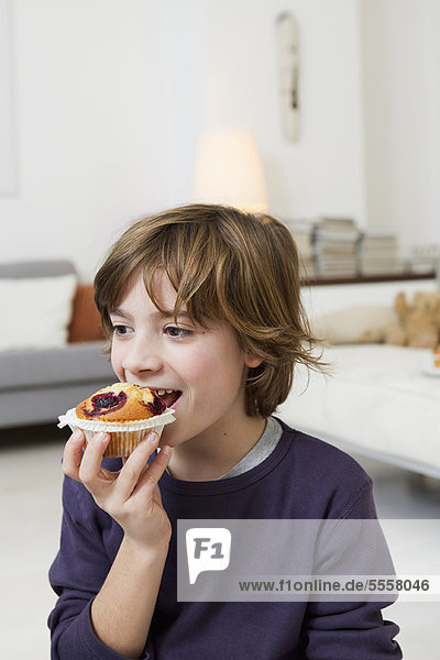Junge - Person  Zimmer  Muffin  essen  essend  isst  Wohnzimmer