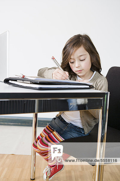Mädchen macht ihre Hausaufgaben am Schreibtisch