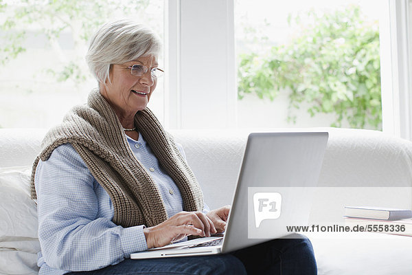 Smiling older woman using laptop