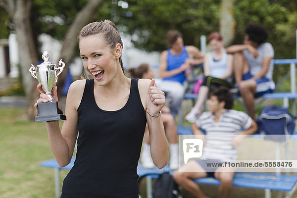 Woman holding trophy in park