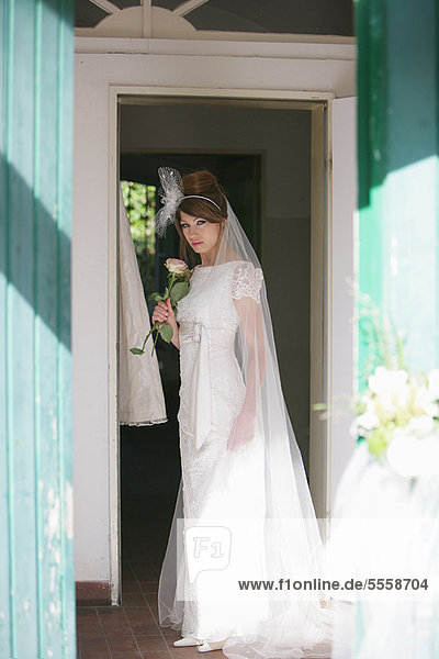 Smiling bride standing in doorway