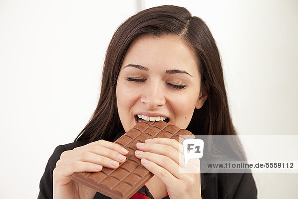 Businesswoman eating bar of chocolate