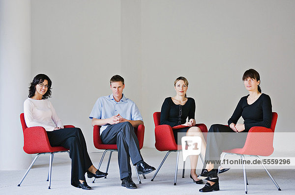 Business people sitting in office chairs