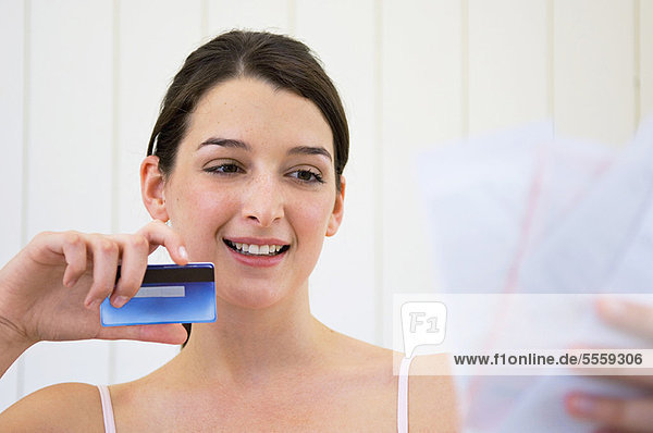 Woman with credit card and bills