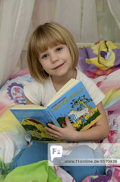 Mädchen  sechs Jahre  liest im Buch Pippi LÂngstrump  Pippi Langstrumpf von Astrid Lindgren