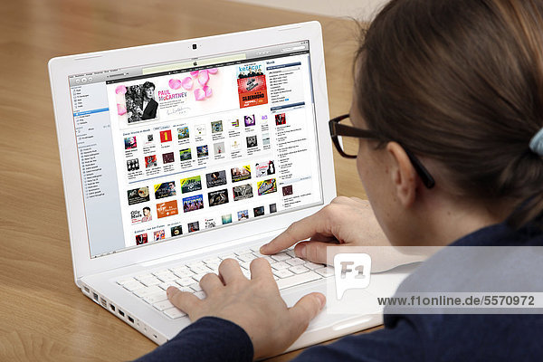 Woman surfing the internet with a laptop  iTunes  Apple Music  software store  user interface for iPhone and iPad