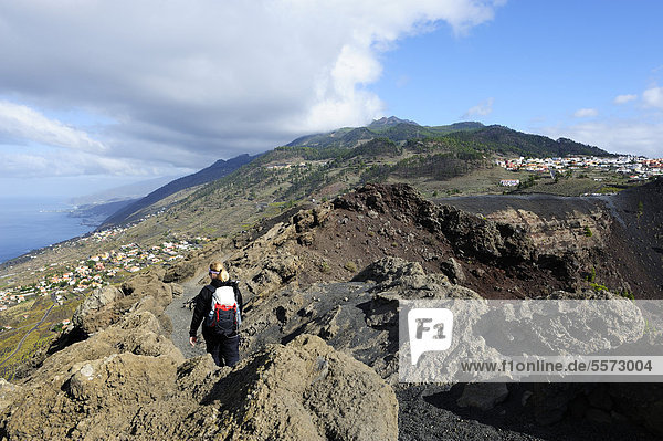 Hiker on the San Antonio volcano near Fuencaliente  town of Los Canarios at back  La Palma  Canary Islands  Spain  Europe  PublicGround