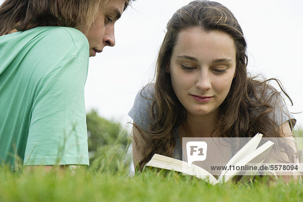 Junges Paar beim gemeinsamen Lesen im Freien