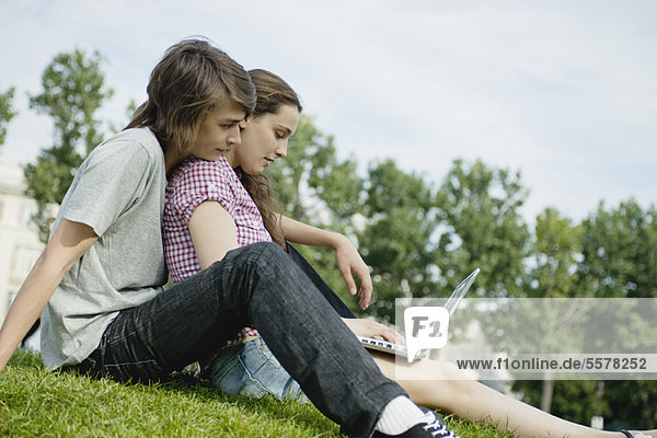 Junges Paar entspannt sich im Freien mit Laptop-Computer