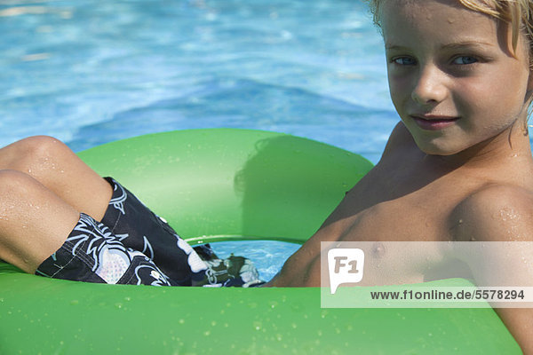 Boy relaxing on float in pool  portrait