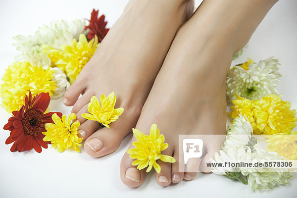 Frau mit Blumen zwischen den Zehen  gepflanzt