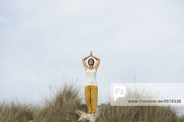 Reife Frau macht Sonnengruß-Yoga-Pose