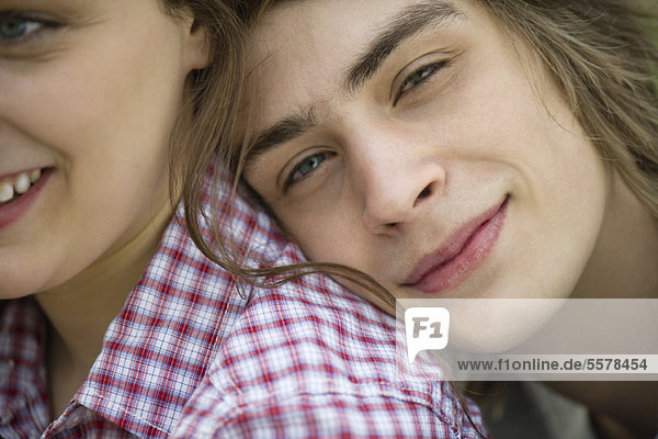 Young man resting head on girlfriend's shoulder  cropped portrait