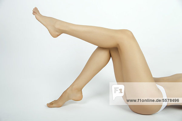 Woman lying on back in underwear with leg up  cropped