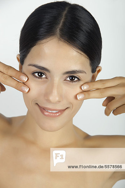 Woman touching cheeks with fingertips  portrait