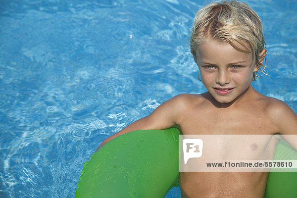 Boy relaxing on float in pool