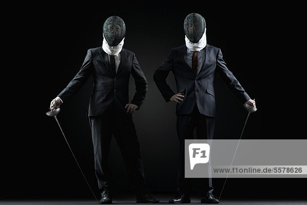 Businessmen with fencing masks and foils