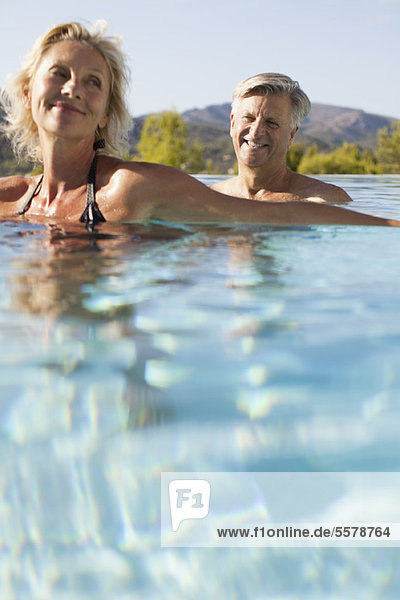 Mature couple relaxing in pool