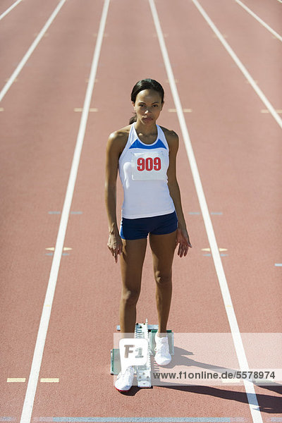 Female runner standing at starting line  portrait