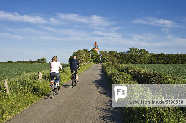 Cyclists in front of the lighthouse on the coastal cliffs of Staberhuk  Fehmarn Island  Baltic Sea  Schleswig-Holstein  Germany  Europe