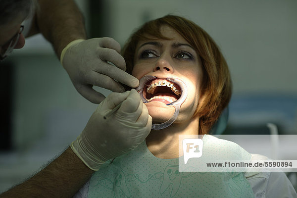 Patientin beim Einsetzen einer Zahnspange beim Zahnarzt