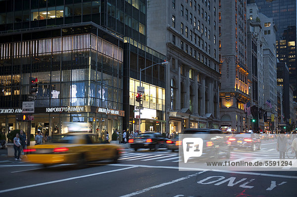 Metropole  Verkehr in der Dämmerung  Autos und Yellow Cab  gelbes Taxi  in der 5th Avenue  Manhattan  New York City  New York  USA  Nordamerika  Amerika