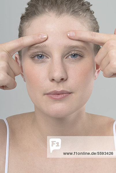 Young woman touching her temples  portrait