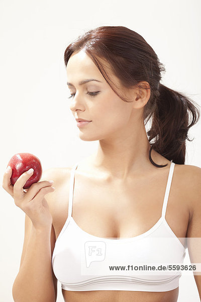 Junge Frau schaut Apfel an