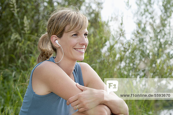 Mid adult woman listening to music  smiling