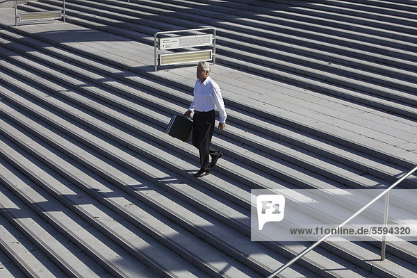 Deutschland  Bayern  München  Geschäftsmann auf der Treppe mit Aktenkoffer