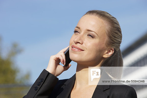 Geschäftsfrau am Telefon  lächelnd