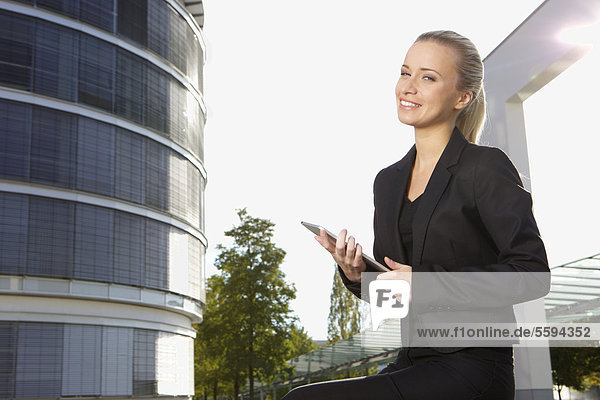 Geschäftsfrau mit digitalem Tablett  lächelnd  Portrait