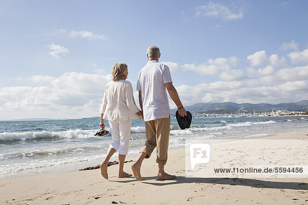 Spain  Mallorca  Senior couple walking along beach
