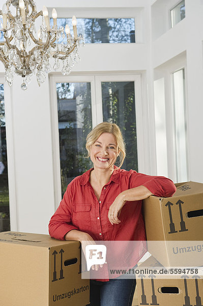 Reife Frau mit Kartons  lächelnd  Portrait