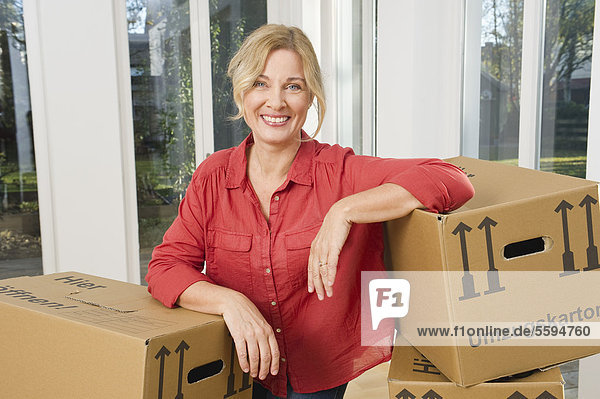 Reife Frau mit Kartons  lächelnd  Portrait