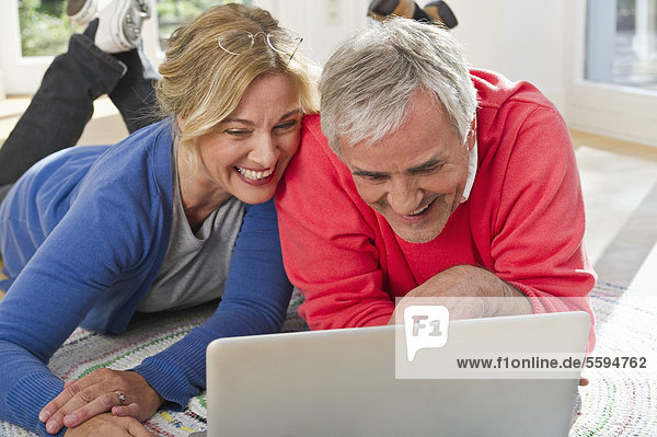 Deutschland  Bayern  Grobenzell  Paar mit Laptop  lächelnd