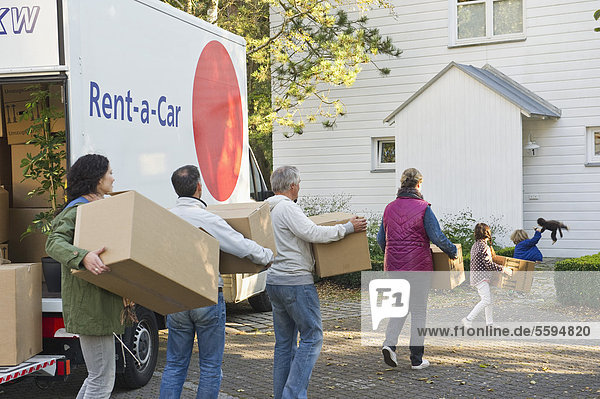 Germany  Bavaria  Grobenzell  Family carrying cardboard box for moving house