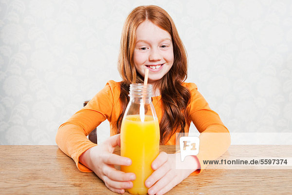 Girl with bottle of orange juice